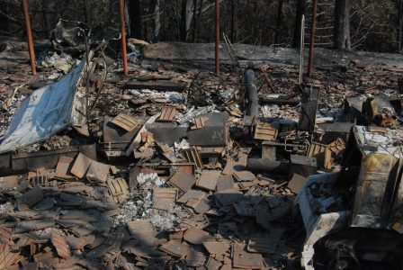 Image of concrete roofing tiles piled on top of burned out equipment