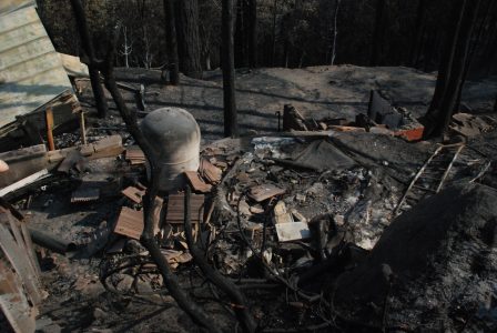 Image of roofing tiles, a blackened tank and rubble behind the garage