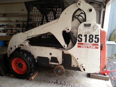 Image of a Bobcat skidsteer with rear wheel removed