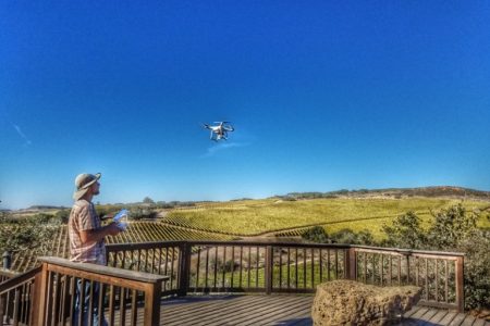 Image of a surveyor controlling a drone flying a short distance away