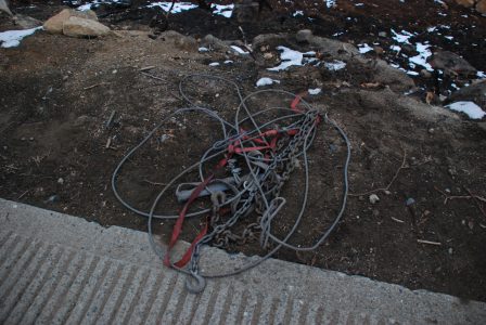 Image of a tangled pile of chains, cables and straps