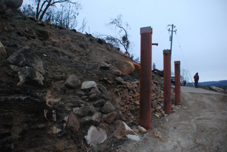 Image of the breezeway support posts and the bare hillside behind them