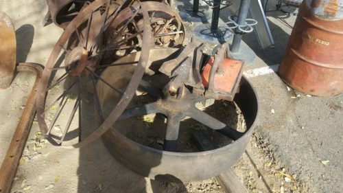 Image of a pile of rusted metal items including the flywheel