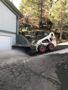 Image of Bobcat with brush attachment sweeping away slushy snow