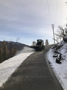 Image of Bobcat brushing snow from the driveway.