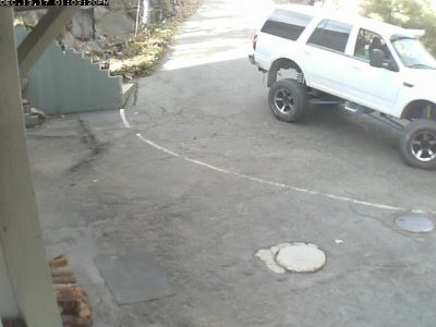 Image of a greatly-lifted white Expedition with blue stabilizers and a sun visor over the windshield