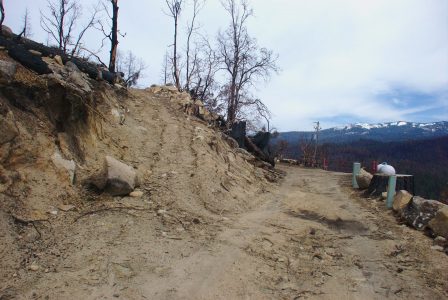 Image of a boulder blocking half of the dirt road