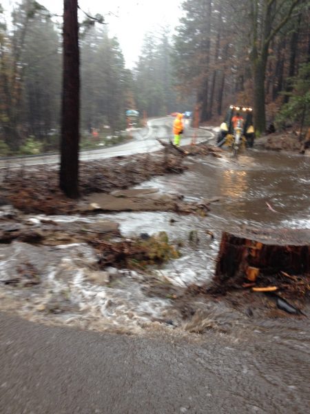 Image of muddy water flowing into a deep pond beside the highway