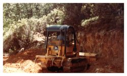 Image of a bulldozer next to a wall of dirt