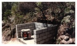 Image of a low u-shaped cinder block wall with an electric generator