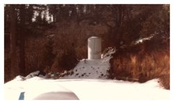 Image of a water tank next to the wall and snow on the ground